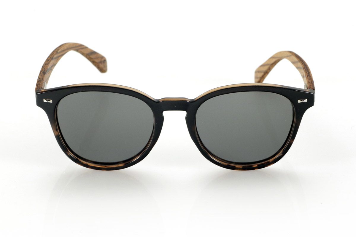 Gafas de Madera Natural de Zebrano TANE. Las gafas de madera TANE fusionan lo clásico y lo artesanal. Su montura de inspiración vintage en acetato Carey aporta un estilo sofisticado y versátil, mientras que sus varillas de madera de Zebrano aportan un carácter cálido y orgánico, resaltando la belleza natural del material. Gracias a su diseño redondeado y atemporal, estas gafas se adaptan a una gran variedad de rostros, ofreciendo un look equilibrado con un toque de personalidad. Sus lentes polarizadas de alta calidad garantizan protección total contra los rayos UV, aportando comodidad visual en cualquier entorno.
Dimensiones de 142x52mm. Calibre de 50, Venta al Por Mayor y Detalle | Root Sunglasses® 