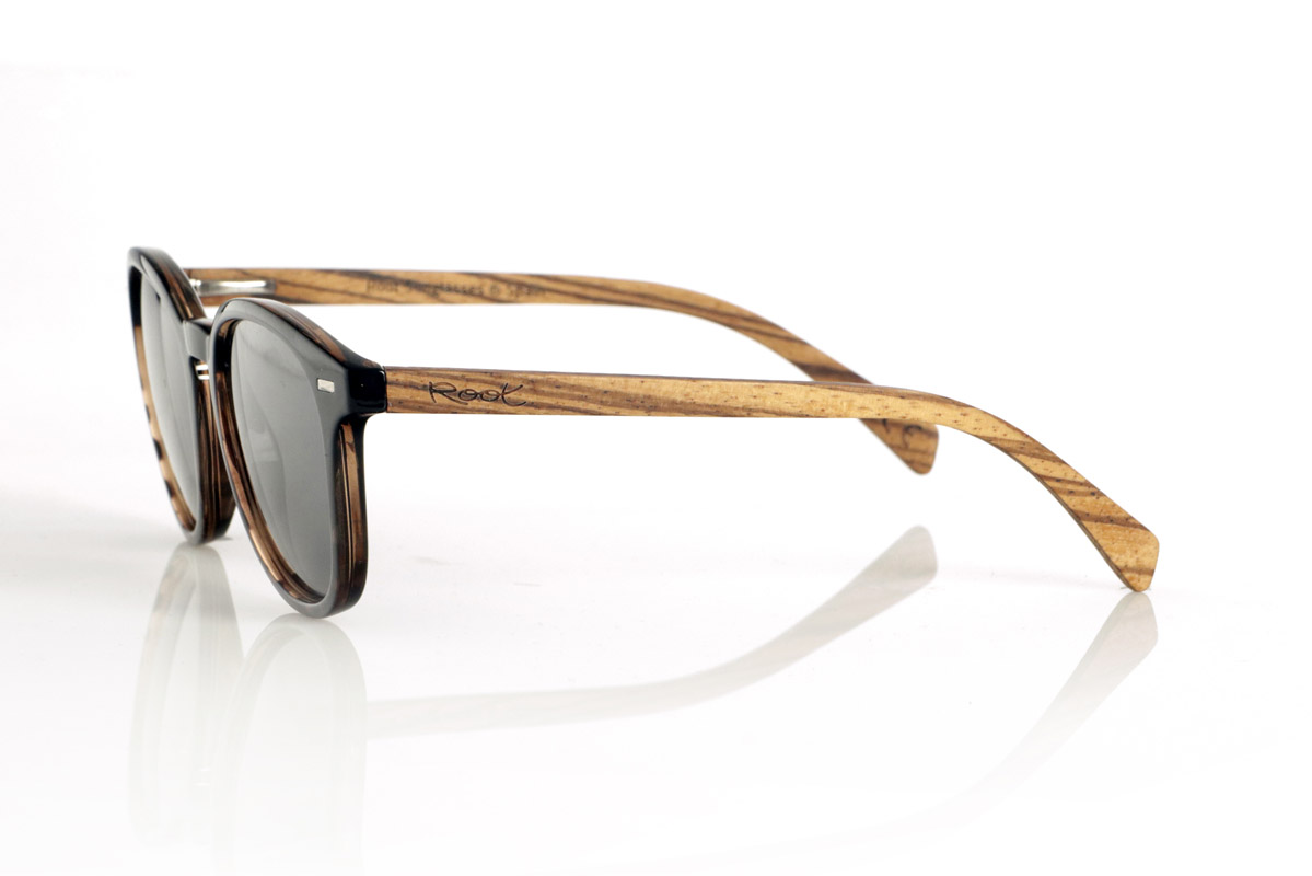 Gafas de Madera Natural de Zebrano TANE. Las gafas de madera TANE fusionan lo clásico y lo artesanal. Su montura de inspiración vintage en acetato Carey aporta un estilo sofisticado y versátil, mientras que sus varillas de madera de Zebrano aportan un carácter cálido y orgánico, resaltando la belleza natural del material. Gracias a su diseño redondeado y atemporal, estas gafas se adaptan a una gran variedad de rostros, ofreciendo un look equilibrado con un toque de personalidad. Sus lentes polarizadas de alta calidad garantizan protección total contra los rayos UV, aportando comodidad visual en cualquier entorno.
Dimensiones de 142x52mm. Calibre de 50, Venta al Por Mayor y Detalle | Root Sunglasses® 