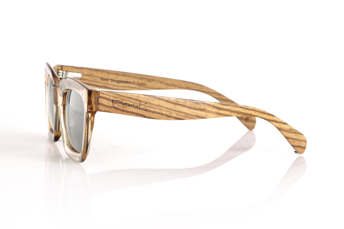 Wood eyewear of Zebrano ZAHIR. The ZAHIR combines a robust and sophisticated design with the natural essence of wood. Its translucent amber-toned acetate frame provides a modern and elegant touch, while its Zebrano wood temples stand out for their unique grain, highlighting the authenticity of each piece. These wooden sunglasses not only offer style, but also functionality, with high-quality polarized lenses that guarantee total UV protection. Ideal for those looking for a balance between contemporary design and natural materials.
Dimensions 147x50mm. Caliber 50. for Wholesale & Retail | Root Sunglasses® 