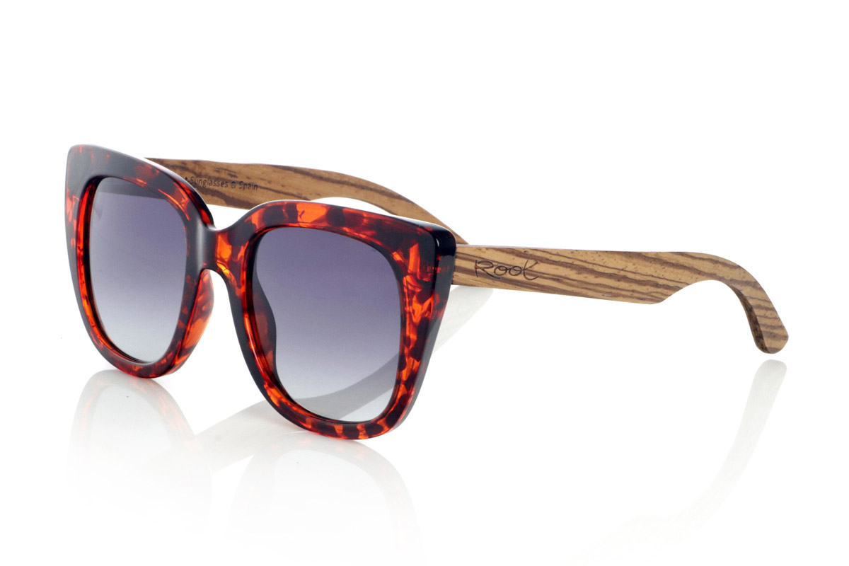 Wood eyewear of  modelo TINAQ. TINAQ sunglasses are a statement of style with character and sophistication. Their wide, glossy acetate frames add a retro and feminine touch, while the Zebrano wood temples add a touch of warmth and exclusivity. These wooden sunglasses combine the elegance of classic designs with the authenticity of natural materials, offering a timeless look with a touch of distinction. Their gradient lenses not only enhance the style, but also guarantee optimal protection against UV rays.

Dimensions: 140x57mm. Caliber: 50. | Root Sunglasses® 