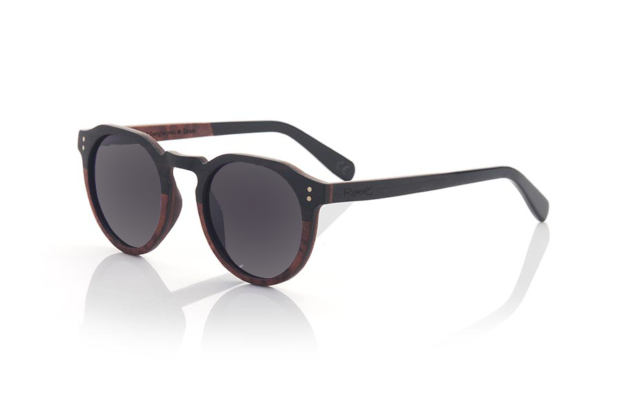 Wood eyewear of Ebony IREM. IREM wooden sunglasses combine elegance and style. They are made entirely with a frame made of laminated EBONY wood on the upper part and Burr wood with a marbled appearance on the lower part and on the inside, while the temples are made of ebony wood on the outside and Burr wood on the inside. inside. It is rounded at the bottom and angular at the brow, making it suitable for both men and women. It is available in two gradient lens colors: brown and grey.
The finish on these sunglasses makes them unique and elegant, perfect for those looking for something different in their fashion accessories. In addition, being made of laminated wood, they are resistant and durable, and the combination of different wood tones adds a touch of style and originality. Front measurement: 141x51mm Caliber: 49 for Wholesale & Retail | Root Sunglasses® 