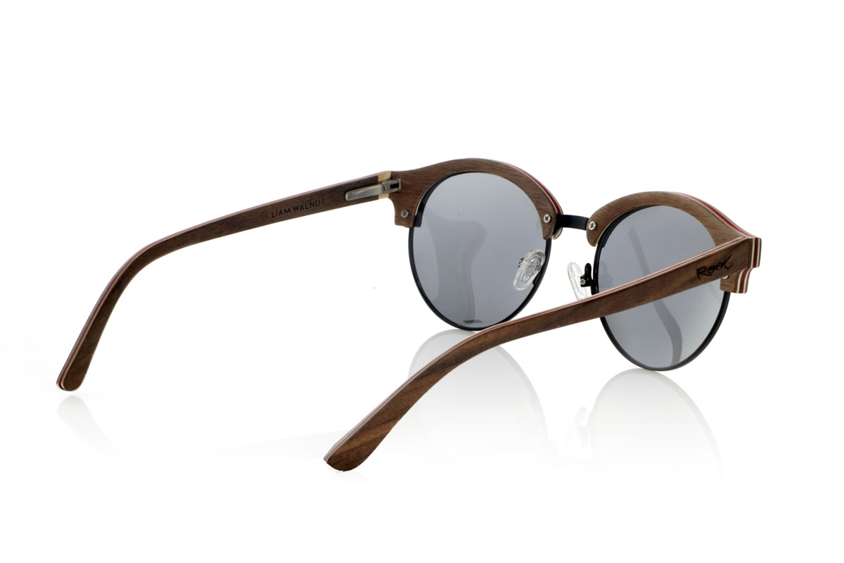 Wood eyewear of Walnut LIAM. The LIAM are handcrafted from laminated walnut wood, with natural maple interior slats and red details. Their design combines the elegance of the classics with a contemporary touch, highlighting the curved lines and the metal structure on the bridge for greater resistance.
The laminated wood provides durability without compromising lightness, allowing a comfortable fit for everyday use. The combination of natural materials and detailed finishes enhances the unique character of each piece.
High-quality polarized lenses offer total UV protection, minimizing reflections and guaranteeing clear vision. A versatile design that unites tradition and modernity in wooden sunglasses designed for those who value authenticity and comfort.
Dimensions 140x50mm. Caliber 50. for Wholesale & Retail | Root Sunglasses® 