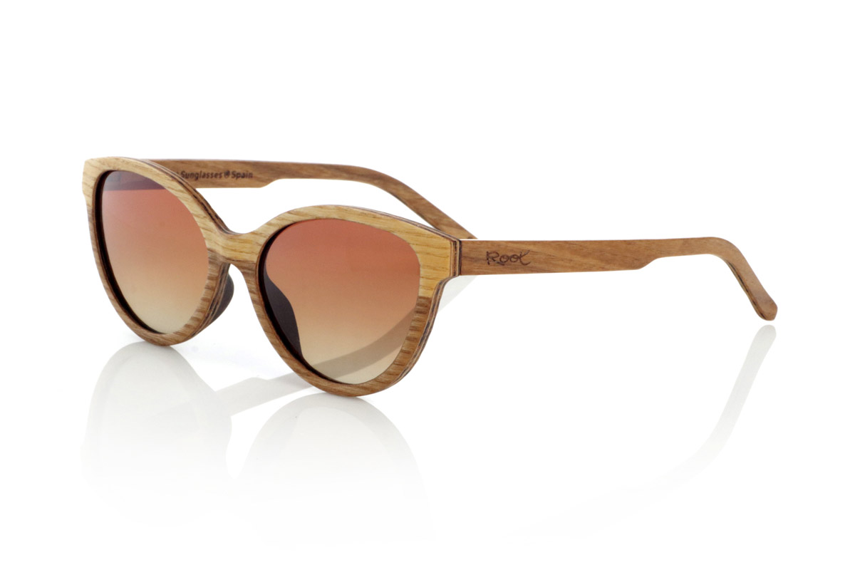 Wood eyewear of Walnut modelo CATHY. CATHY sunglasses are handcrafted from laminated light and dark walnut wood combined, creating a natural and elegant contrast. Its smaller design than others and with soft lines and rounded frame reminiscent of the cat's eye provides a balance between sophistication and versatility, adapting to different styles and faces.
The laminated wood structure not only highlights the natural grain of the material, but also provides great strength and comfort. Thanks to its lightness and ergonomic fit, this model is ideal for daily use without compromising aesthetics.
They incorporate polarized lenses that offer total protection against UV rays and reduce glare, guaranteeing clear vision in any environment. A timeless design that fuses craftsmanship and functionality in unique wooden glasses.

Dimensions: 135x48 mm. Caliber 52. | Root Sunglasses® 