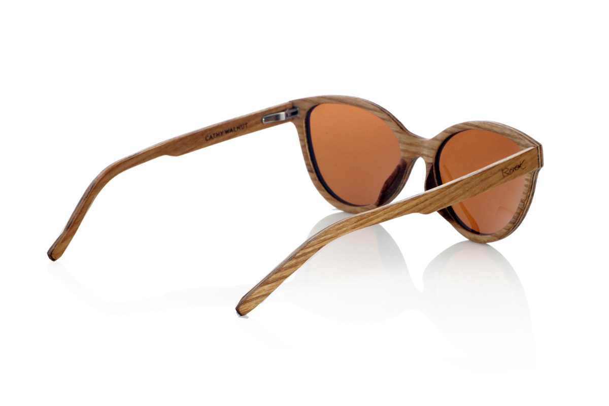 Wood eyewear of Walnut CATHY. CATHY sunglasses are handcrafted from laminated light and dark walnut wood combined, creating a natural and elegant contrast. Its smaller design than others and with soft lines and rounded frame reminiscent of the cat's eye provides a balance between sophistication and versatility, adapting to different styles and faces.
The laminated wood structure not only highlights the natural grain of the material, but also provides great strength and comfort. Thanks to its lightness and ergonomic fit, this model is ideal for daily use without compromising aesthetics.
They incorporate polarized lenses that offer total protection against UV rays and reduce glare, guaranteeing clear vision in any environment. A timeless design that fuses craftsmanship and functionality in unique wooden glasses.

Dimensions: 135x48 mm. Caliber 52. for Wholesale & Retail | Root Sunglasses® 