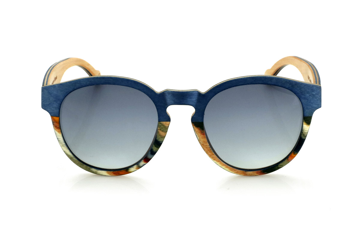 Wood eyewear of Maple WANZ. WANZ sunglasses are made from a combination of laminated woods that provide a unique and distinctive style. Its blue maple wood front merges with a multicoloured rainbow skateboard sheet, creating a dynamic and original visual effect. The temples, made from blue tinted maple with a natural maple wood interior, complement the design with a balance between modernity and warmth.

Thanks to their layered wood construction, these wooden sunglasses guarantee strength without compromising comfort. They incorporate high-quality polarised lenses that offer full UV protection and reduce glare, improving visual clarity.

A versatile model that stands out for its bold design and its inspiration from nature. Dimensions: 138x52mm. Caliber 49. for Wholesale & Retail | Root Sunglasses® 