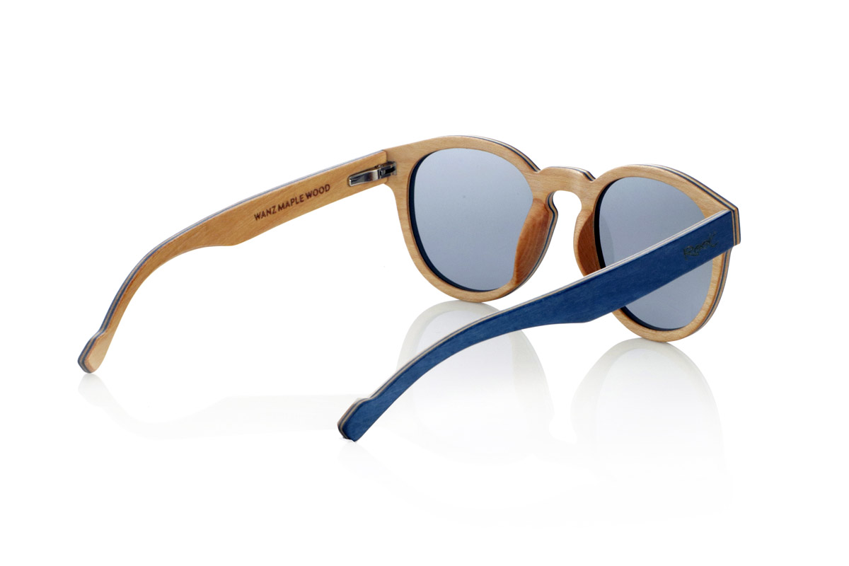 Wood eyewear of Maple WANZ. WANZ sunglasses are made from a combination of laminated woods that provide a unique and distinctive style. Its blue maple wood front merges with a multicoloured rainbow skateboard sheet, creating a dynamic and original visual effect. The temples, made from blue tinted maple with a natural maple wood interior, complement the design with a balance between modernity and warmth.

Thanks to their layered wood construction, these wooden sunglasses guarantee strength without compromising comfort. They incorporate high-quality polarised lenses that offer full UV protection and reduce glare, improving visual clarity.

A versatile model that stands out for its bold design and its inspiration from nature. Dimensions: 138x52mm. Caliber 49. for Wholesale & Retail | Root Sunglasses® 