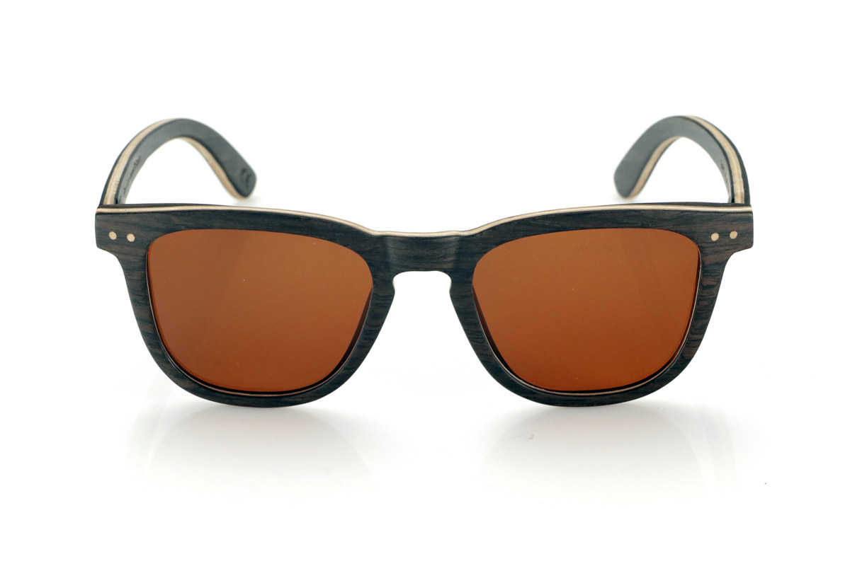 Wood eyewear of Oak ENRICO. ENRICO wooden sunglasses are made with a laminated black oak structure on the outside and inside, with a thin layer of natural maple interspersed for subtle contrast. Its classic design with a straight front and defined lines conveys balance and solidity.

Double-knit details on the front highlight its artisanal character, while its laminated structure provides strength without compromising comfort. Polarized lenses guarantee clear vision, reducing glare and offering total UV protection.

A timeless model that combines noble materials with a functional design for everyday use.

Dimensions: 142x47mm. Caliber 49. for Wholesale & Retail | Root Sunglasses® 