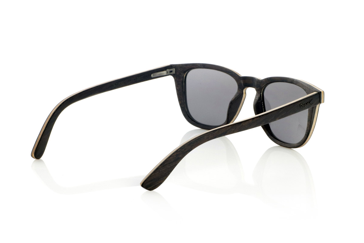 Wood eyewear of Oak ENRICO. ENRICO wooden sunglasses are made with a laminated black oak structure on the outside and inside, with a thin layer of natural maple interspersed for subtle contrast. Its classic design with a straight front and defined lines conveys balance and solidity.

Double-knit details on the front highlight its artisanal character, while its laminated structure provides strength without compromising comfort. Polarized lenses guarantee clear vision, reducing glare and offering total UV protection.

A timeless model that combines noble materials with a functional design for everyday use.

Dimensions: 142x47mm. Caliber 49. for Wholesale & Retail | Root Sunglasses® 