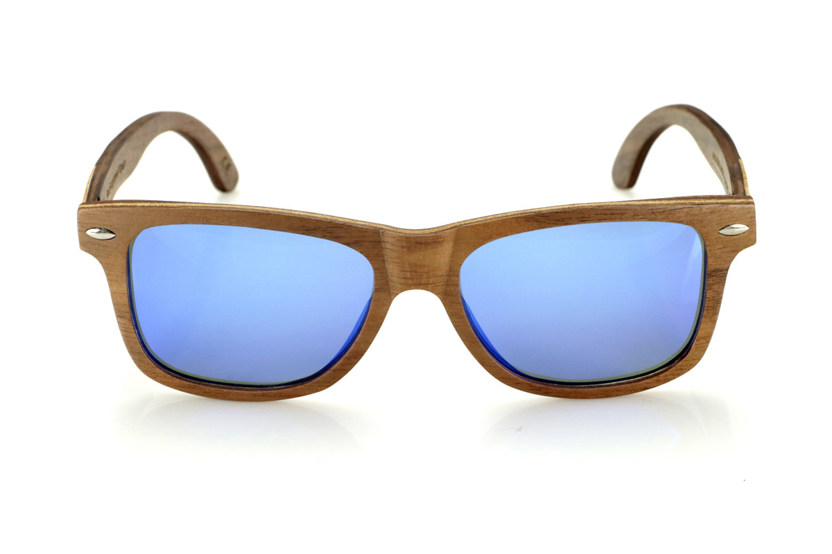 Wood eyewear of Walnut WOODSUNSET SK. The Woodsunset wooden sunglasses are made from black walnut wood, offering an elegant and timeless design with a natural finish. Its laminated structure includes a natural maple interlayer, providing a subtle contrast that enhances its sophistication.

The temples feature a unique detail with a combination of walnut and oak, giving this model a distinctive touch. In addition, the front features small metal ornaments, which not only reinforce the structure, but also add a vintage feel to its design.

Thanks to its classic and versatile shape, the Woodsunset are an excellent choice for both men and women looking for wooden glasses with character and style.

Measurements: 147x47 Caliber: 49 for Wholesale & Retail | Root Sunglasses® 